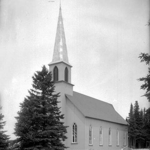 Une petite église située dans un secteur boisé.